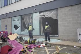 Police officers by smashed windows after trouble flared during an anti-immigration demonstration outside the Holiday Inn Express in Rotherham, South Yorkshire. Picture: Danny Lawson/PA Wire