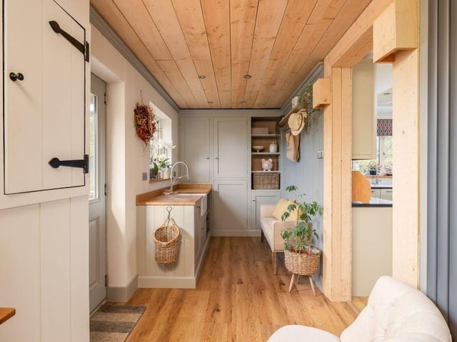 Fitted cupboards, a Belfast sink and space for laundry appliances make this a useful working area.