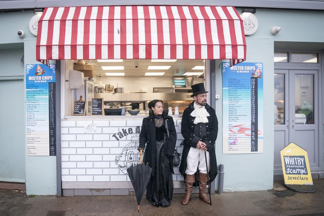 Whitby Goth Weekend attendees standing outside of a takeaway shop.