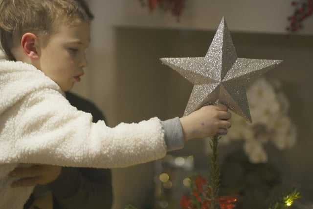 Liz and Kelvin's son putting the star on the tree