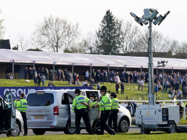 Protesters are detained by police during day three of the Randox Grand National Festival at Aintree Racecourse, Liverpool.