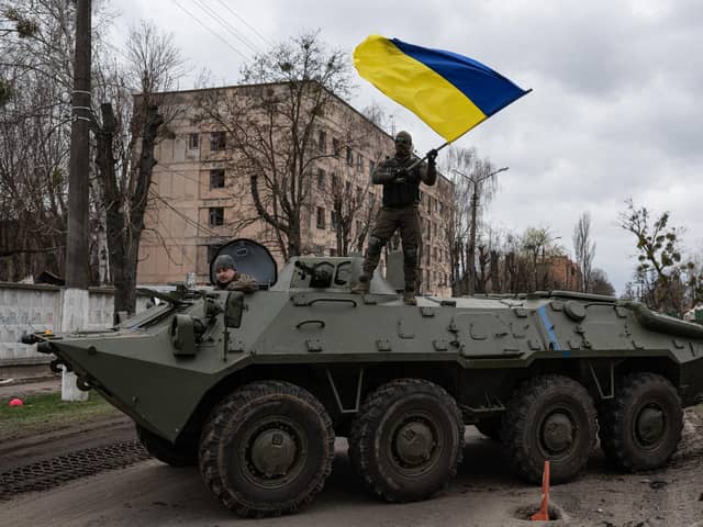A Ukrainian soldier waves Ukrainian national flag while standing on top of an armoured personnel carrier (APC) on April 8, 2022 in Hostomel, Ukraine. (Photo by Alexey Furman/Getty Images)