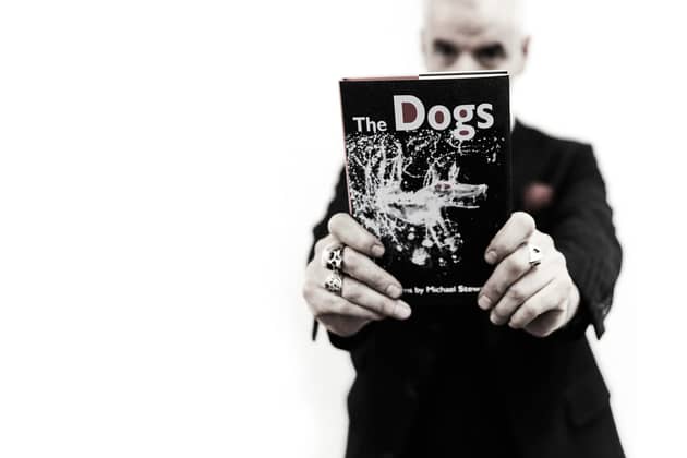 Author Michael Stewart and his latest book The Dogs, a collection of poetry. Picture: Paul Crowther