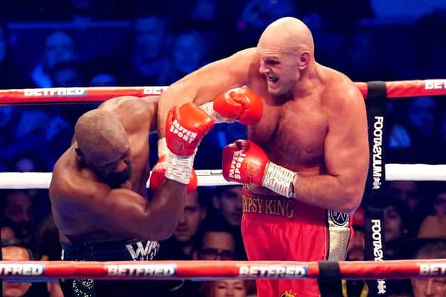 Tyson Fury (right) lands a heavy right on opponent Derek Chisora during their WBC World Heavyweight title fight at the Tottenham Hotspur Stadium on Saturday night - Fury retaining his belt.