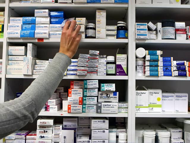 A pharmacist stocks shelves at a chemist. PIC: Julien Behal/PA Wire