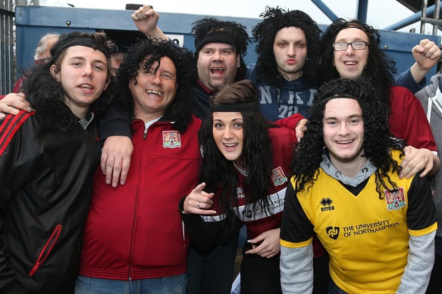 Northampton Town fans wear long hair wigs and headbands in homage to John-Joe O'Toole prior to the Sky Bet League Two match between Mansfield Town and Northampton Town at One Call Stadium on February 14, 2015.