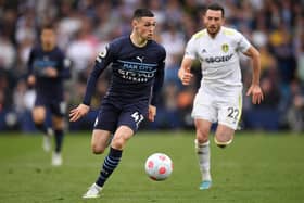 Manchester City's English midfielder Phil Foden runs with the ball during the English Premier League football match between Leeds United and Manchester City at Elland Road in Leeds, northern England on April 30, 2022. (Photo by OLI SCARFF/AFP via Getty Images)