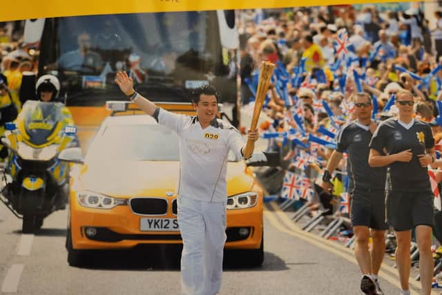 Alan Mak carrying the Olympic Torch in Bedale in 2012.