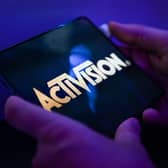 A visitor plays the game 'Call of Duty' of Activision on a mobile phone at the Samsung mobile booth at the Gamescom video game fair in Cologne on August 24, 2022. (Photo by Ina FASSBENDER / AFP)