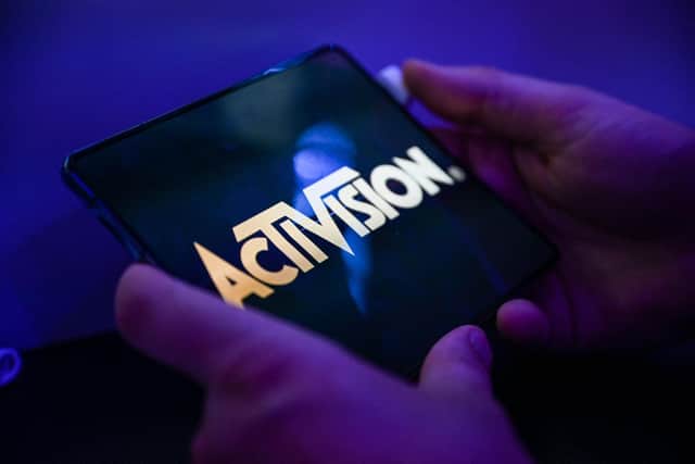 A visitor plays the game 'Call of Duty' of Activision on a mobile phone at the Samsung mobile booth at the Gamescom video game fair in Cologne on August 24, 2022. (Photo by Ina FASSBENDER / AFP)
