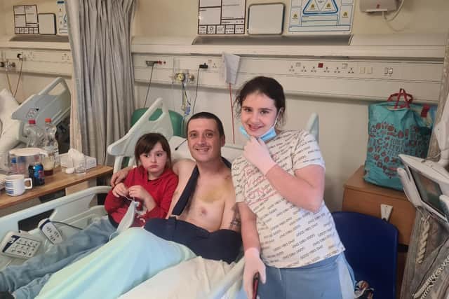 Karlos Bingham in hospital with his daughters, aged 11 and eight