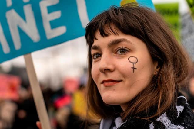 A protester has the female symbol painted on her face during a march of supporters and feminists for women's rights and over climate emergency at the occasion of the International Women's Day in Warsaw, Poland. (Pic credit: Wojtek Radwanski / AFP via Getty Images)