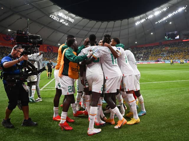 TOPSHOT - Senegal's players celebrate after Senegal's forward #18 Ismaila Sarr scored their team's first goal during the Qatar 2022 World Cup Group A football match between Ecuador and Senegal at the Khalifa International Stadium in Doha on November 29, 2022. (Photo by OZAN KOSE/AFP via Getty Images)