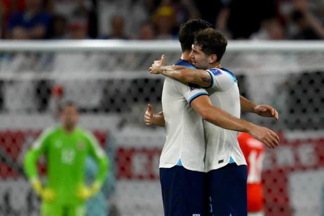 England's defender #06 Harry Maguire and England's defender #05 John Stones greet each other after defeating Wales 3-0 in the Qatar 2022 World Cup Group B football match between Wales and England at the Ahmad Bin Ali Stadium in Al-Rayyan, west of Doha on November 29, 2022. (Photo by NICOLAS TUCAT / AFP) (Photo by NICOLAS TUCAT/AFP via Getty Images)