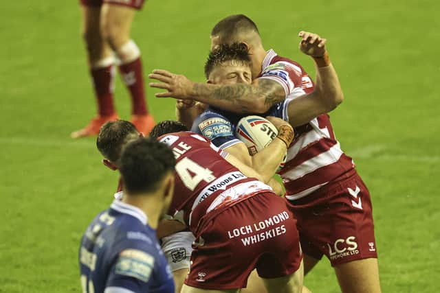 Hull FC's Davy Litten gets a high tackle from Wigan's Brad O'Neill. (Photo: Paul Currie/SWpix.com)