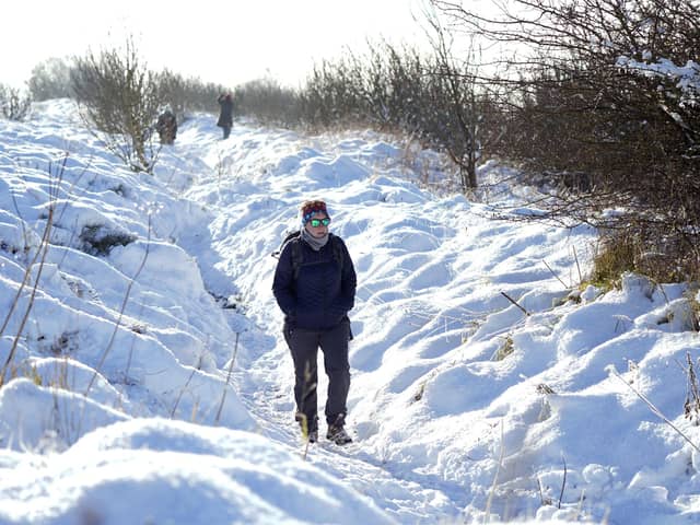 A person walks through snow above the Hole of Horcum at the North York Moors National Park, as scattered weather warnings for snow and ice are in place across the UK as temperatures plunged below freezing overnight. The Met Office has issued yellow warnings through Saturday morning for the northern coast and southwest of Scotland, as well as southwest and the eastern coast of England.Danny Lawson/PA Wire