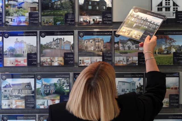 A woman looking at houses for sale in an estate agents. PIC: David Cheskin/PA Wire