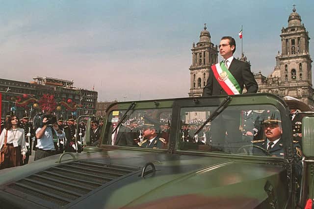 Mexico's former President Ernesto Zedillo rides on a military vehicle while reviewing troops in front of the Presidential Palace, 01 December 1994. (Photo: JORGE UZON/AFP via Getty Images)