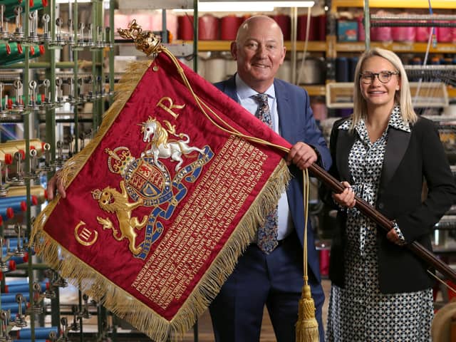 The new hand crafted Blues and Royals sovereign standard bearing the insignia of King Charles III is displayed by Robin and Rosie Wright of Wyedean, before it leaves the firm’s factory in Haworth, West Yorkshire for Saturday’s Trooping of the Colour. Lorne Campbell/Guzelian