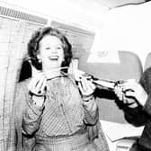 Prime Minister Margaret Thatcher pulls a Christmas cracker with her Chief Press Officer Bernard Ingham on the VC-10 taking her from Washington to London. It was the last leg of her round-the-world diplomatic trip.