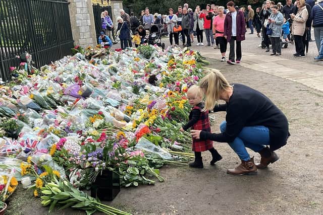 Amanda Bartlett with her daughter Ayla, lay flowers at Cambridge Gate, Long Walk, Windsor, following the death of Queen Elizabeth II on Thursday. (Ben Mitchell/PA Wire)