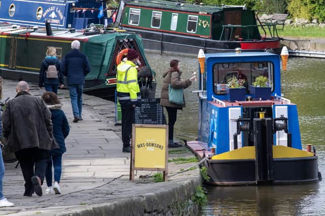 Customers queue for the Ice Cream Tug Boat moored in Skipton photographed for The Yorkshire Post by Tony Johnson. This is the tenth year of trading on the boat in the North Yorkshire town.   4th May 2023