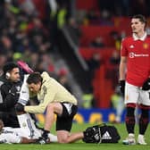Leeds United's Colombian striker Luis Sinisterra receiving medical attention during the English Premier League football match between Manchester United and Leeds United at Old Trafford in Manchester, north west England, on February  8, 2023. (Photo by OLI SCARFF/AFP via Getty Images)