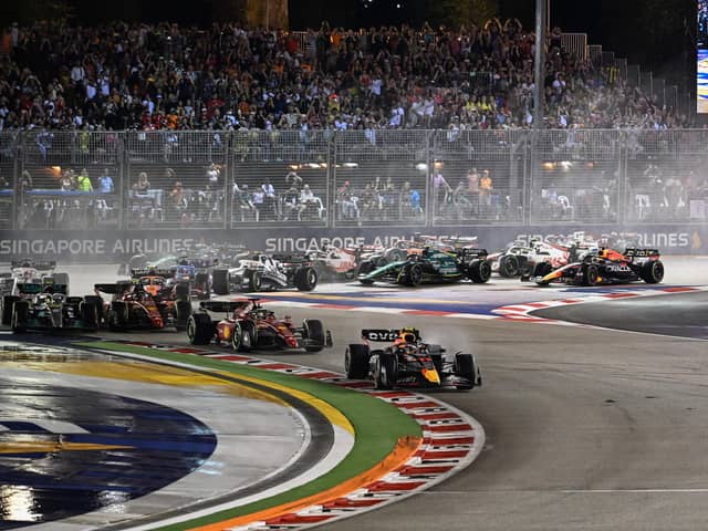 Red Bull Racing's Mexican driver Sergio Perez (C) leads at the start of the Formula One Singapore Grand Prix night race at the Marina Bay Street Circuit in Singapore on October 2, 2022. (Photo by ROSLAN RAHMAN / AFP) (Photo by ROSLAN RAHMAN/AFP via Getty Images)