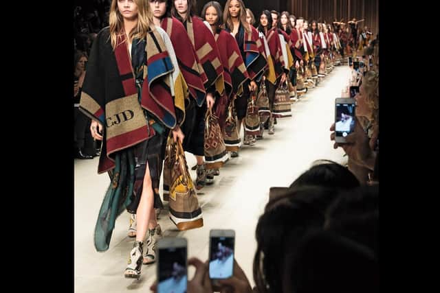 Cara Delevingne leads out a row of monogrammed ponchos for the AW14 collection. Picture courtesy of Burberry.