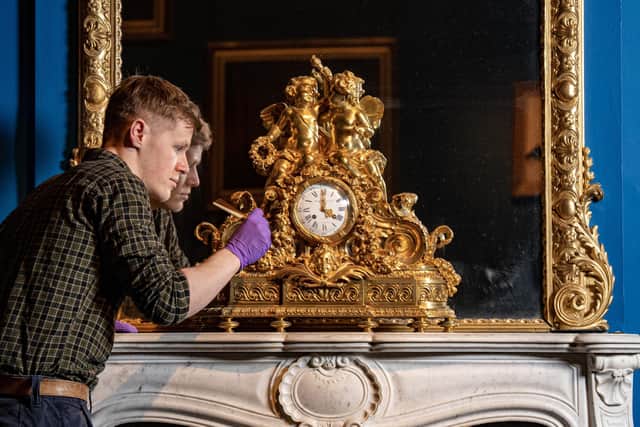 Collections Assistant Joe Kinsey at The Bowes Museum, Barnard Castle, dusts a gilt bronze French Mantle clock from 1855, back on display.