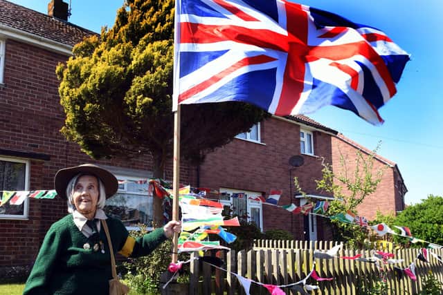 Muriel Berzins from Aldborough near Hull   a Land Girl  during World War 2  pictured  in her origional  Land Girl uniform outside her house decorated for VE day