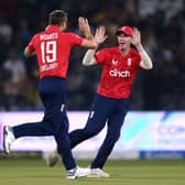 England's Harry Brook, right, celebrates with teammate Chris Woakes after taking the catch of Pakistan's Babar Azam during the seventh twenty20 cricket match between Pakistan and England (AP Photo/K.M. Chaudary)