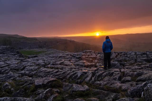 A walker watches the Sunrise at Malham Cove on the first Bank Holiday of 2022.
3rd January 2022.  Picture Bruce Rollinson