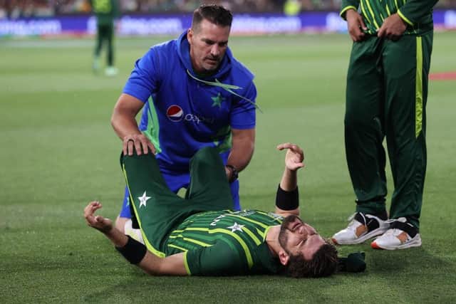 Shaheen Shah Afridi receives treatment after injuring his knee in catching Yorkshire's Harry Brook. Afridi was able to bowl only one more ball before limping off in a big blow to Pakistan's hopes. Photo by Mark Kolbe/Getty Images.