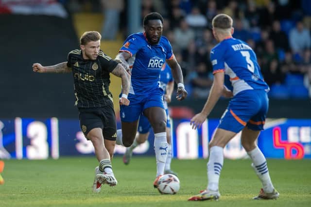 Halifax Town's Jamie Cooke is closed down by Oldham's Manny Monthe and Mark Kitching. Photo: Tony Johnson.