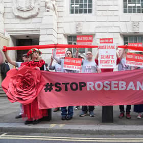 Organisers from Fossil Free London demonstrate using red ribbon to visually emphasise the Government's legally binding commitment to the Paris Climate Agreement, as a decision on Jackdaw and Rosebank oil fields is awaited, outside the Department For Energy Security And Net Zero in Whitehall, London. Picture date: Tuesday October 13, 2026. PA Photo. Photo credit should read: Maja Smiejkowska/PA Wire