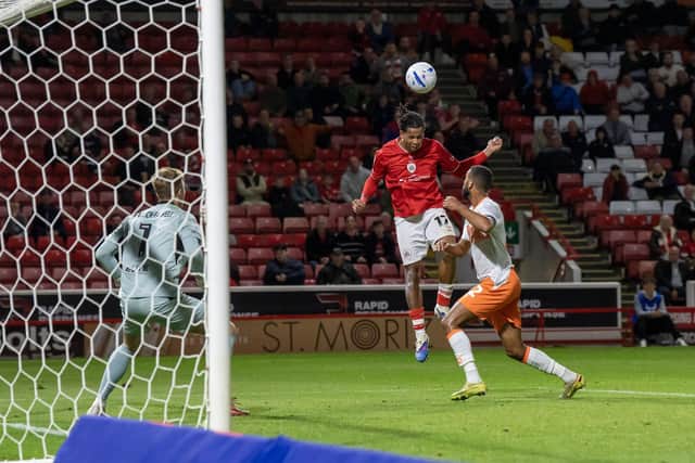 Barnsley's Amani Richards nods the ball over Bailey Peacock-Farrell to score the late winner against Blackpool. Photo: Tony Johnson.