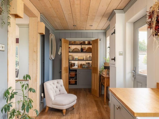Fitted cupboards, shelving and concealed lighting make the most of this compact walk-in pantry.
