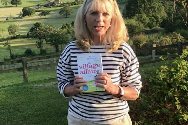 Julie Houston in the Yorkshire countryside with her book, A Village Affair.