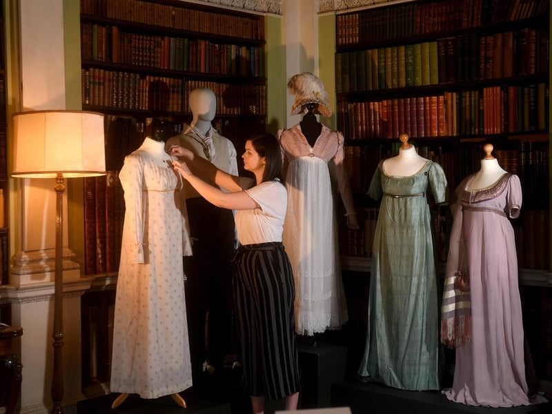 Niamh Kelly, Collections Care and Access Officer, adjusting Elizabeth Bennet's long-sleeved dress from the BBC's 1995 adaptation of Pride and Prejudice in the Old Library.
