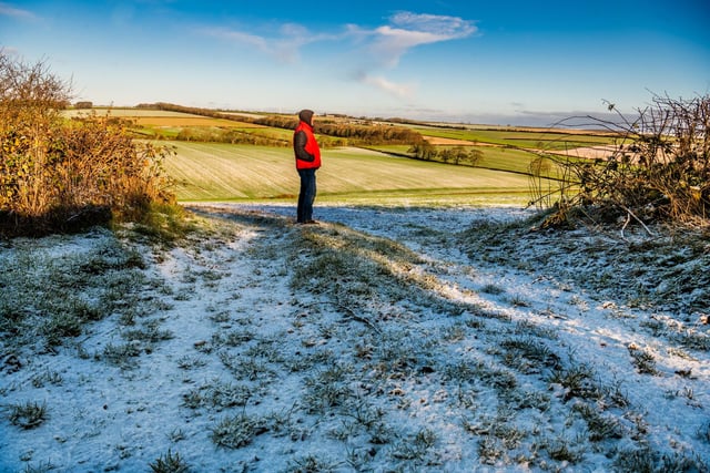 A man stops to admire the lightly snow covered Wolds between Kilham and Thwing.
