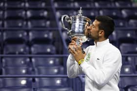 Novak Djokovic of Serbia poses for the media as he kisses his winners trophy after defeating Daniil Medvedev of Russia during their Men's Singles Final at Flushing Mewadows in New York (Picture: Clive Brunskill/Getty Images)