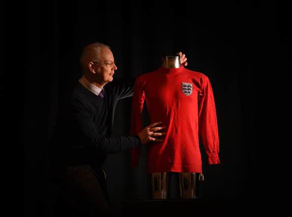 Toy and Sporting Specialist Keegan Harrison pictured with the Shirt of World Cup winning England player Alan Ball who played in the 1966 World Cup against West Germany, goes up for auction at Tennants Auctioneers, Leyburn. Picture by Simon Hulme 16th November 2022










