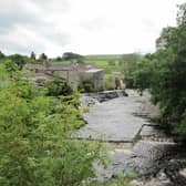 The Archimedes’ screw of the community-owned River Bain Hyrdo Ltd hydro plant can be seen turning from the road bridge over the River Bain in the village of Bainbridge.