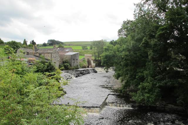 The Archimedes’ screw of the community-owned River Bain Hyrdo Ltd hydro plant can be seen turning from the road bridge over the River Bain in the village of Bainbridge.