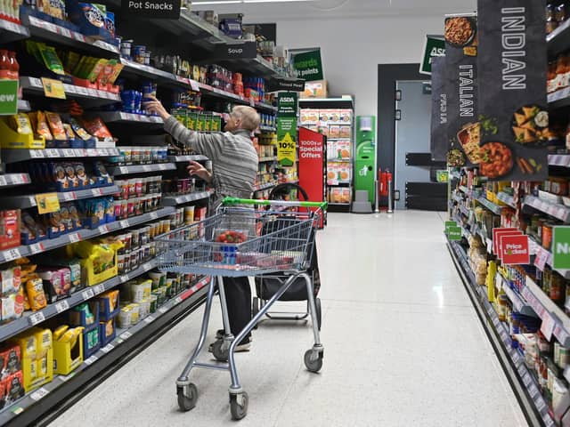 A customer looks at some goods at the Asda supermarket, in Aylesbury, England, on August 15, 2023. (Photo by JUSTIN TALLIS/AFP via Getty Images)