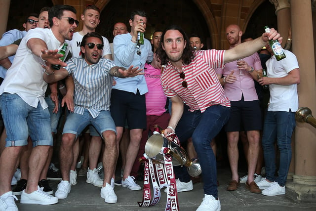 John-Joe O'Toole of Northampton Town celebrates with the Sky Bet League Two Champions Trophy and team mates on the steps of the Town Hall during the Northampton Town Sky Bet League Two Winners Bus Parade on May 8, 2016.
