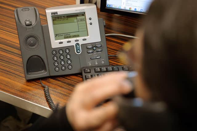 A file photo of a woman using a landline phone in an office. PIC: PA