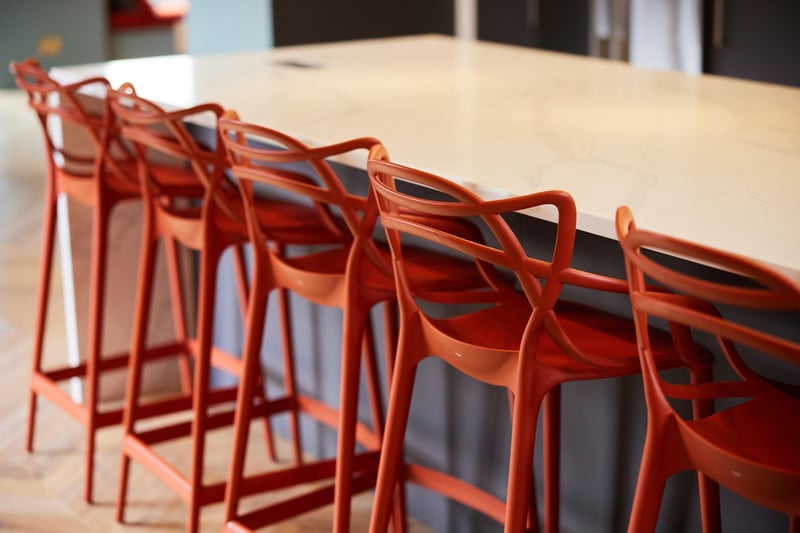 The island seating is stylish and adds a pop of bright orange to the kitchen