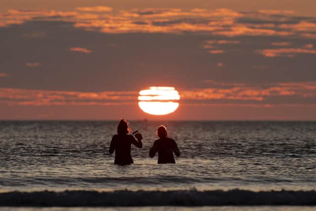 Two woman take a dip in the sea off Cayton Bay in Scarborough as the sun rises on the Summer Solstice. Picture: Danny Lawson/PA Wire